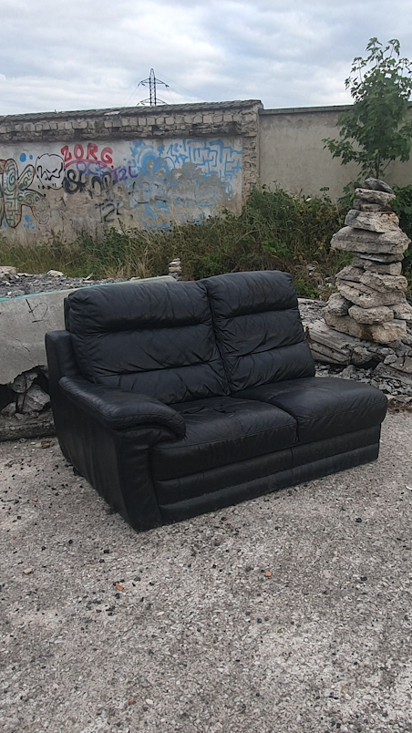 a black couch in a dump